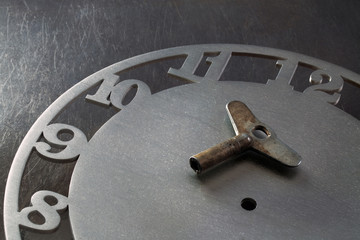 Rusty key lays on the watch face