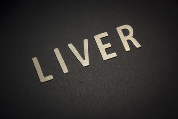 Liver written with wooden letters on a black background