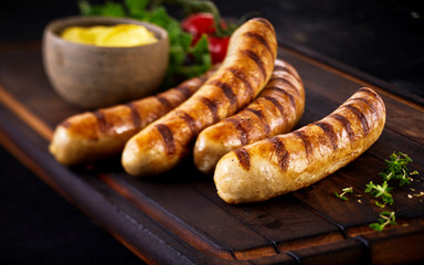 Four tasty grilled pork sausages from a BBQ - obrazy, fototapety, plakaty