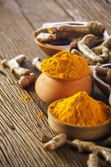 Turmeric roots on wooden background