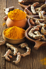 Turmeric roots on wooden background