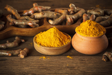 Turmeric roots on wooden background