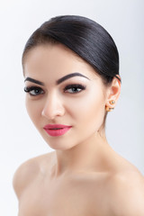 Obraz premium Front portrait of attractive young brunette woman on grey background. girl with clean skin