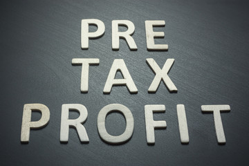 Fototapeta premium Profit before taxes written with wooden letters on a black background