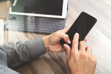 Hand using mobile payments online shopping,omni channel,icon customer network,in modern office wooden desk, blank interface screen,filter effect