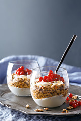 Cereals with greek yogurt and red currants. Healthy breakfast in a glass. Copy space