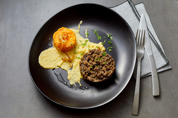 Black bowl with egg and sausage