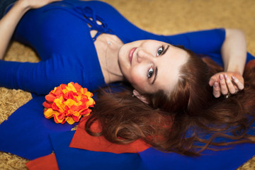 Smiling woman lying on the floor surrounded by gift decorations. Upper view.