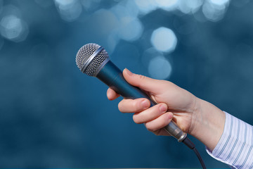 Hand of a businesswoman with a microphone .