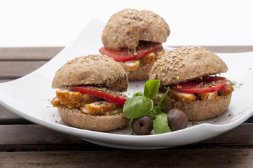 mini chicken sandwich, tomato, basil, olive on white plate for catering, events and party