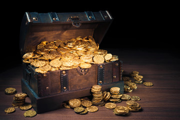 Open treasure chest with gold coins on a dark background