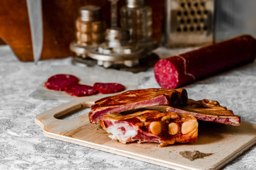 On the kitchen table is smoked meat and sausage