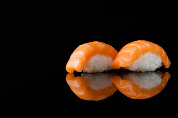 closeup of sushi with rice on black background with reflection