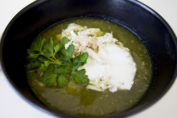 green soup from spinache and brocolli with chicken and crem in the black plate and snacks