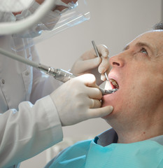Dentist is drilling a tooth to a sick person