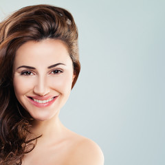 Smiling Woman Fashion Model with Blowing Hair. Beautiful Friendly Girl with Curly Hairstyle. Beauty, Facial Treatment and Cosmetology