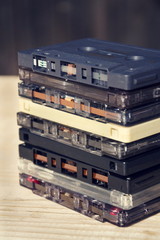 Filtered retro compact cassette audio magnetic tapes on wooden background