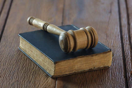 Judge's gavel with old book on old wood table