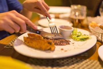 Girl eating meat with salad in a restaurant