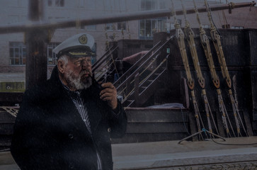 Kapitän am Boot im Regen