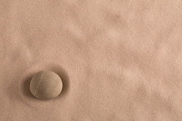Fototapeta na wymiar zen stone minimal background for yoga, meditation or relaxation. Meditation rock in sand with copy space.