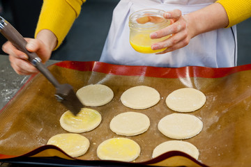 confectioner lubricates cookie dough egg in the pan