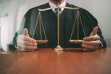 justice and law concept.Male judge in a courtroom with the balance scale on wood table - obrazy, fototapety, plakaty