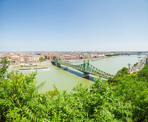 Fototapeta premium Freedom Bridge connecting Buda and Pest across Dunabe River in Budapest, Hungary - view from a hill