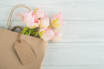 Pink spring tulips in bag with blank tag