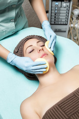 doctor beautician cleanses skin woman with sponge. cosmetology treatment skincare face. Spa procedures