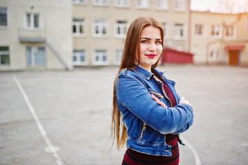 Obraz premium Young chubby teenage girl wear on red dress and jeans jacket posed against school backyard.