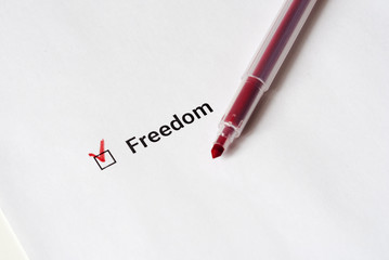 Democratic policy. Red pen and the inscription Freedom with check mark on the white paper