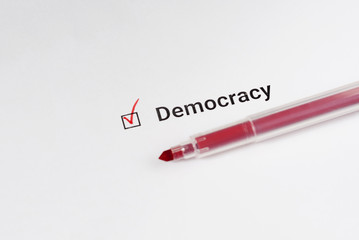 Obraz premium Questionnaire. Red marker and the inscription Democracy with check mark on the white paper