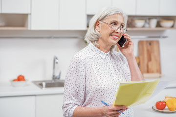 Mature woman calling utility service at home