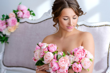 Naklejka premium very beautiful pregnant woman with a big bouquet of flowers in a gentle interior 