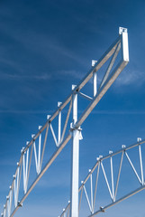 Galvanized steel roof truss construction frames with deep blue sky in the background