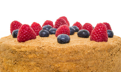 Honey cake decorated with raspberries and blueberries isolated.