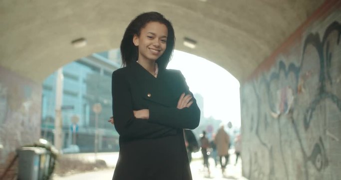 Portrait of young African American woman looking to a camera, outdoors.