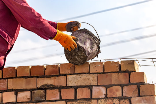 Worker builds a brick wall in the house