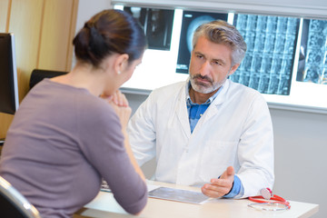 Doctor in consultation with woman, grave expression