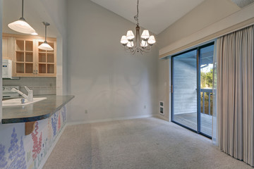 Empty dining space with vaulted ceiling and grey walls