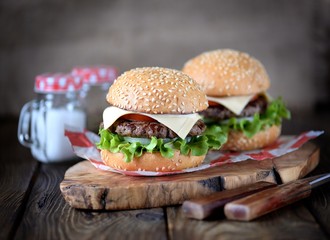 Homemade burgers with pickled onions, tomato and cheese.