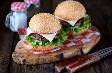 Homemade burgers with pickled onions, tomato and cheese.