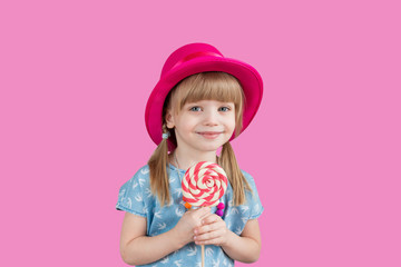 Isolated on bright background, studio. Beautiful little girl with lollipop