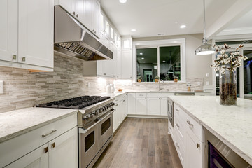 Gourmet kitchen features white cabinetry