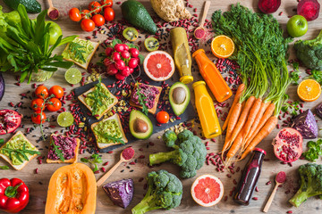 Healthy vegan food. Sandwiches and fresh vegetables on wooden background. Detox diet. Different colorful fresh juices. top view