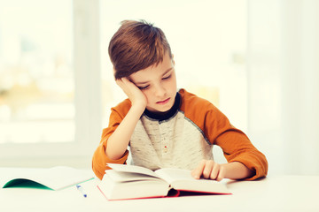 student boy reading book or textbook at home