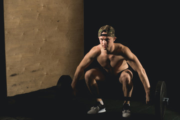Handsome weightlifter preparing for training. Shallow depth of field, selective focus on hands and...