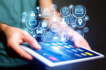 Concept of multimedia icon flying over device on a technology interface - Internet concept