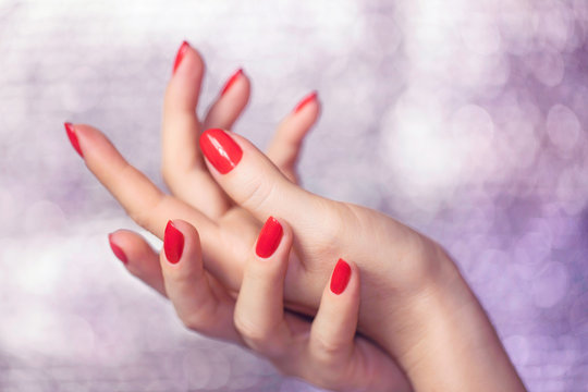 Close up on beautiful female hands with Red manicure.
